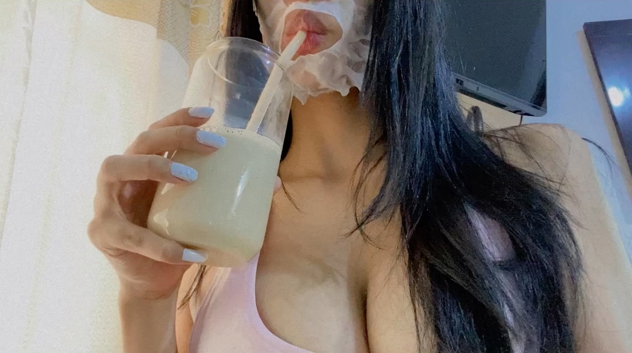 kat from Colombia in a close-up moment, face mask on, sipping through a straw
